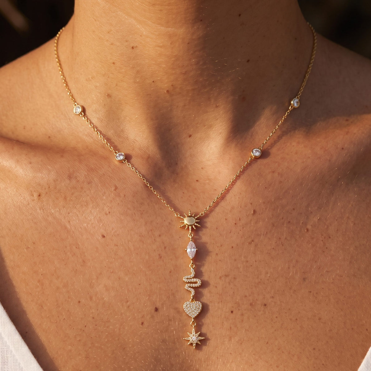 Close-up of the Amulet Lariat Necklace at the throat featuring sparkling crystal charms