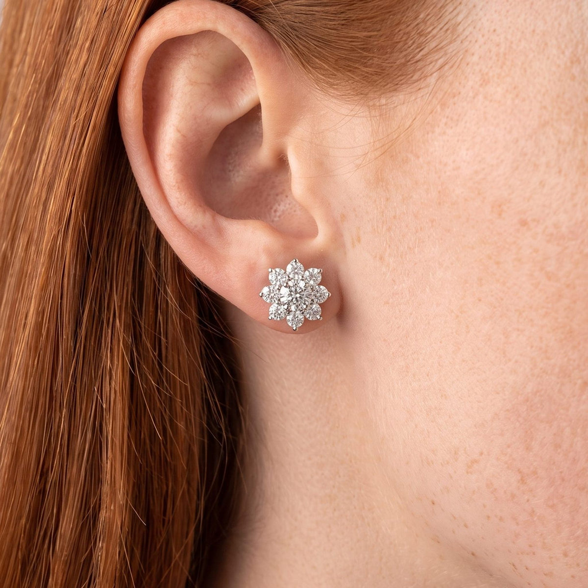 Woman wearing the Andora Silver Crystal Earrings flat to the lobe in a sparkling flower shape