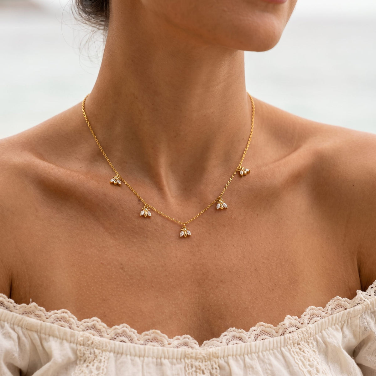 Wider view of a woman wearing the Bee Charm Necklace