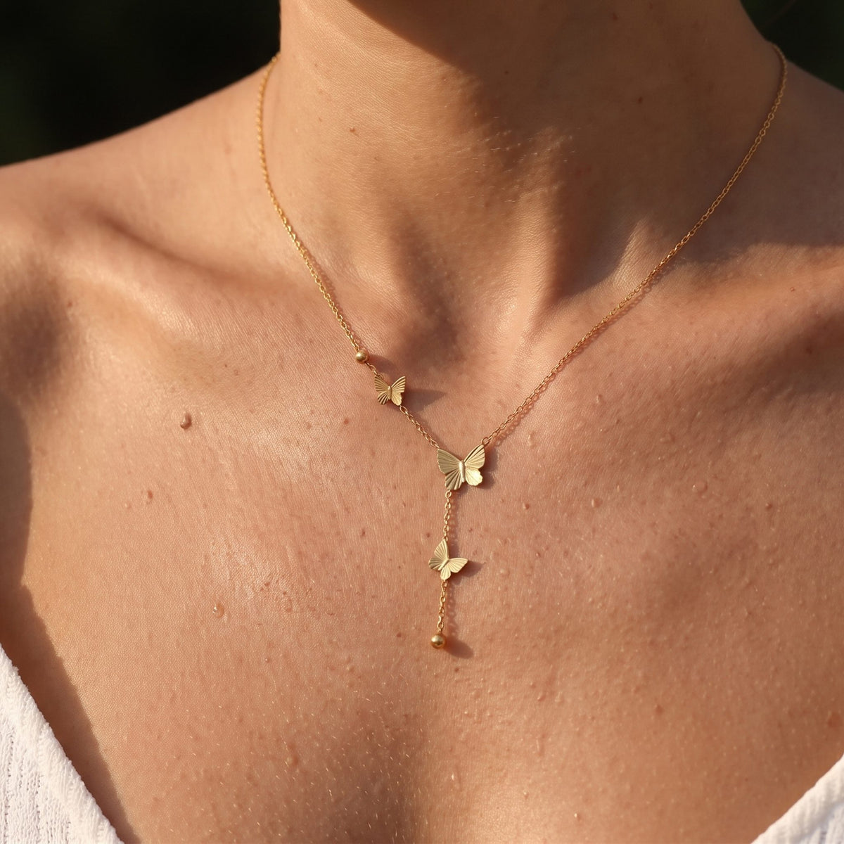 Close-up of the Butterfly Lariat Necklace worn on the neckline