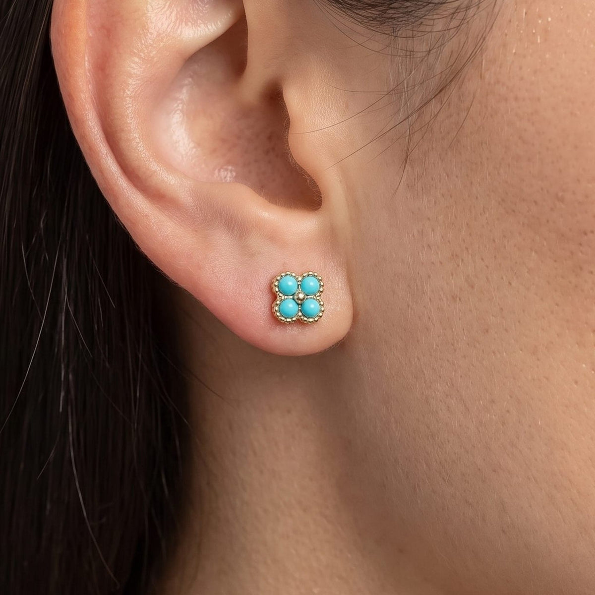 Woman wearing the Cassidy Turquoise Stud Earrings on the lobe, featuring four round turquoise stones in gold
