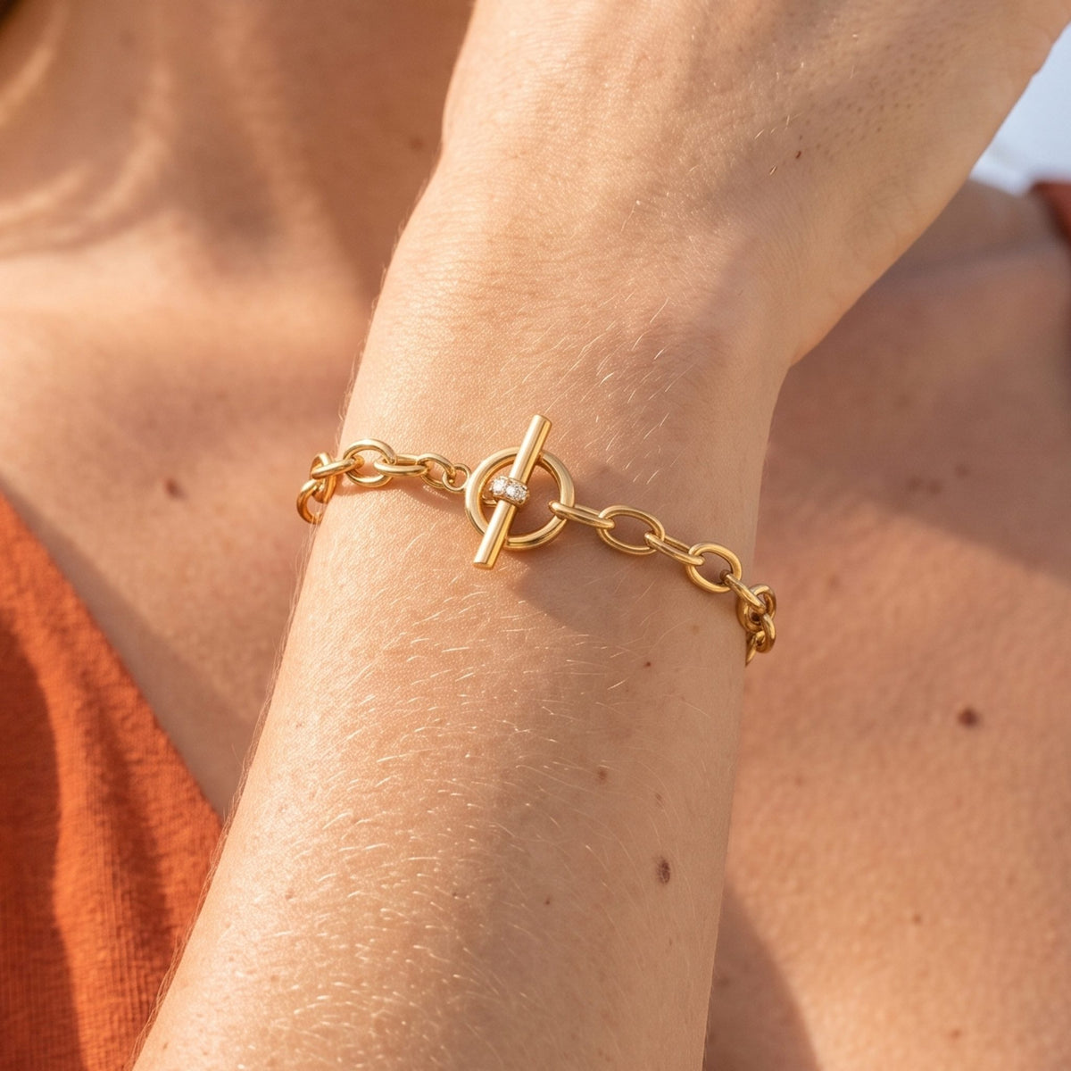 Close-up of the Circle Toggle Bracelet on the wrist, highlighting the small crystal-accented bar closure in sunlight