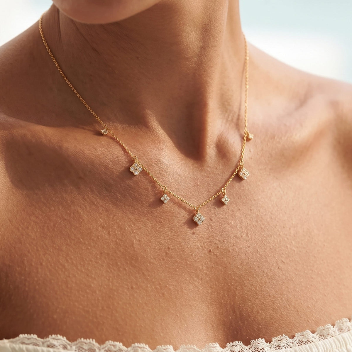 Close-up of the Clover Charm Necklace worn on the neckline