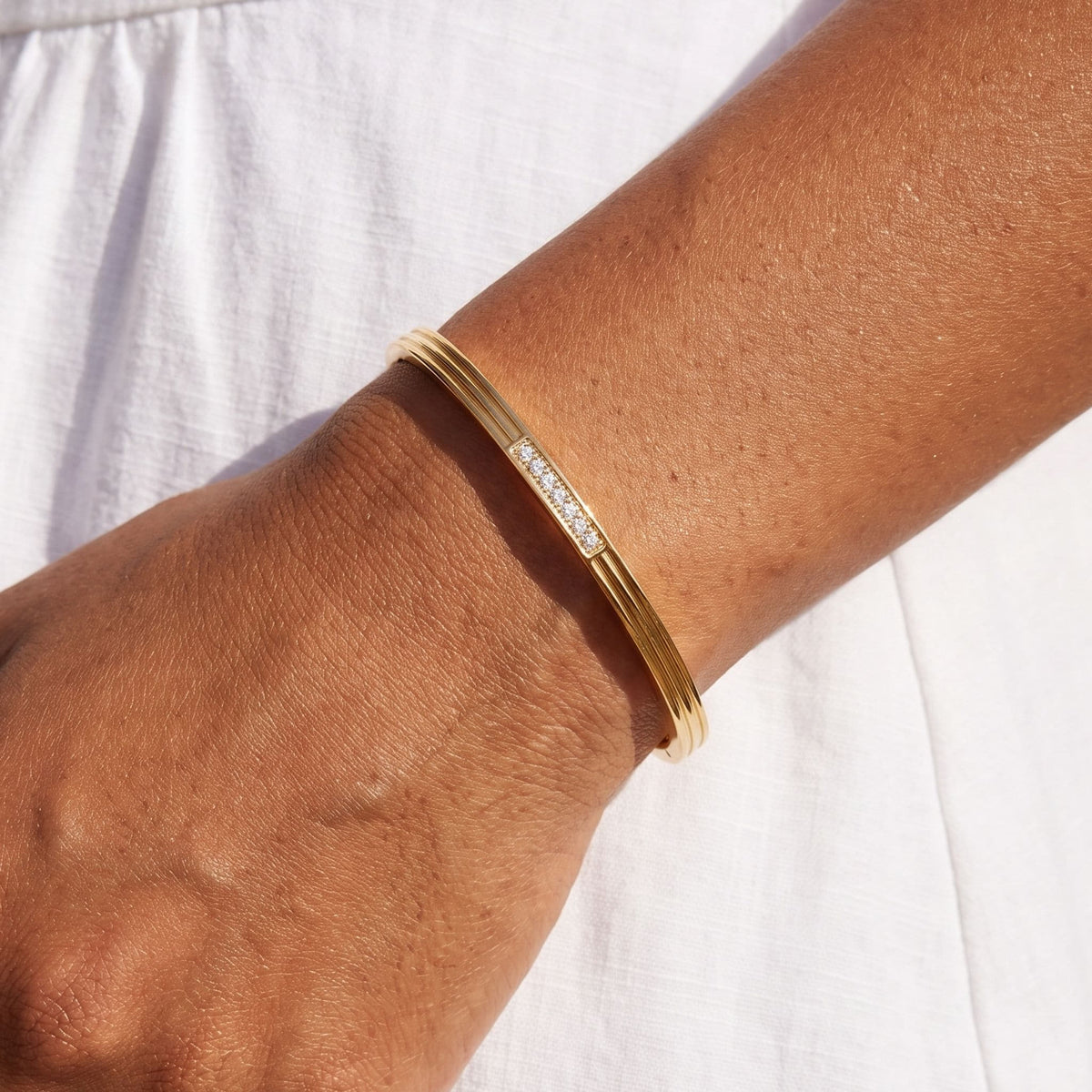 Crystal Panel Bangle worn on the wrist, photographed in natural daylight.