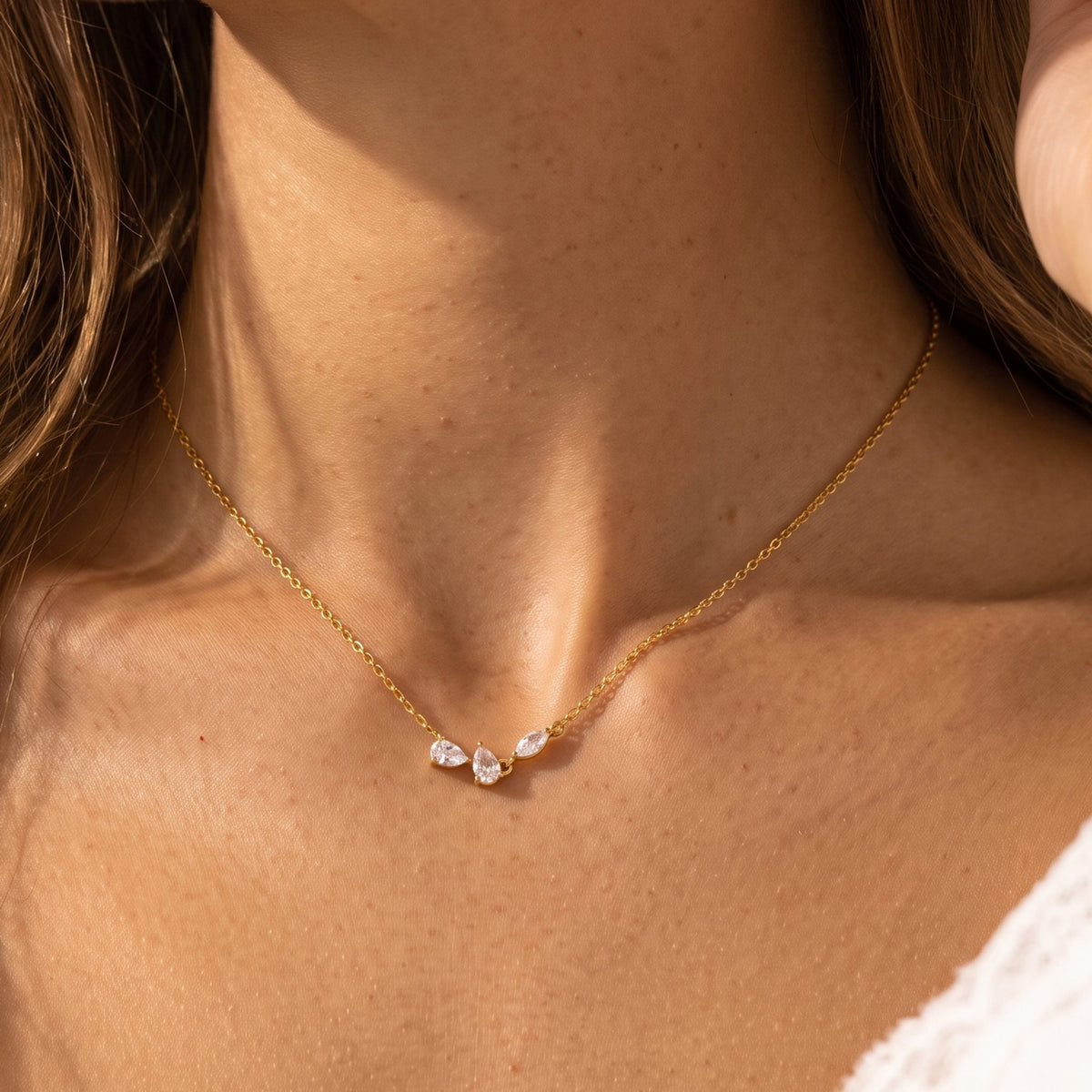 Close-up of the Crystal Petal Necklace at the collarbone, showing three delicate crystal petals