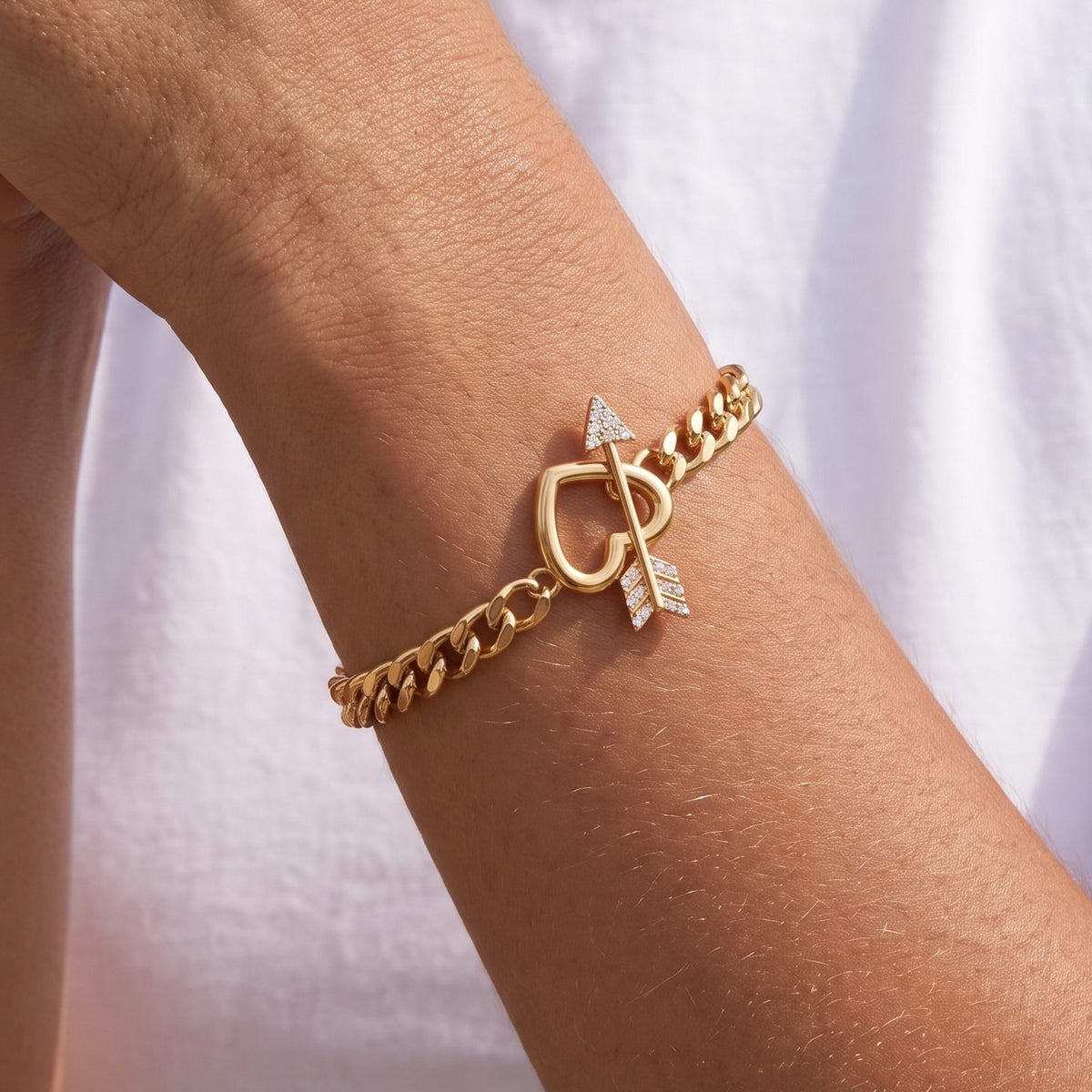 Close-up of the Cupid Bracelet on the wrist featuring a crystal-paved arrow and heart charm