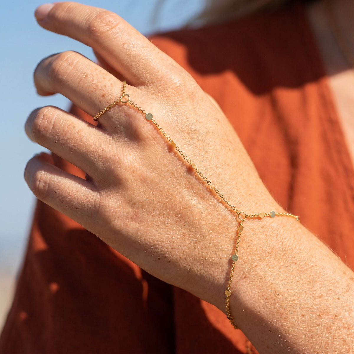 Disc Hand Chain worn across the back of the hand, with the ring on the finger and the chain at the wrist.