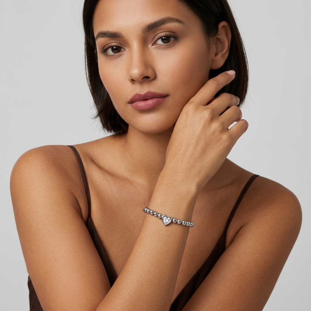 Woman with dark hair wearing the Aurélie silver beaded bracelet, hand raised to her cheek