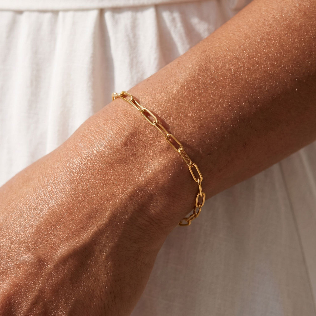 Fine Paperclip Bracelet worn on the wrist, photographed in natural daylight.
