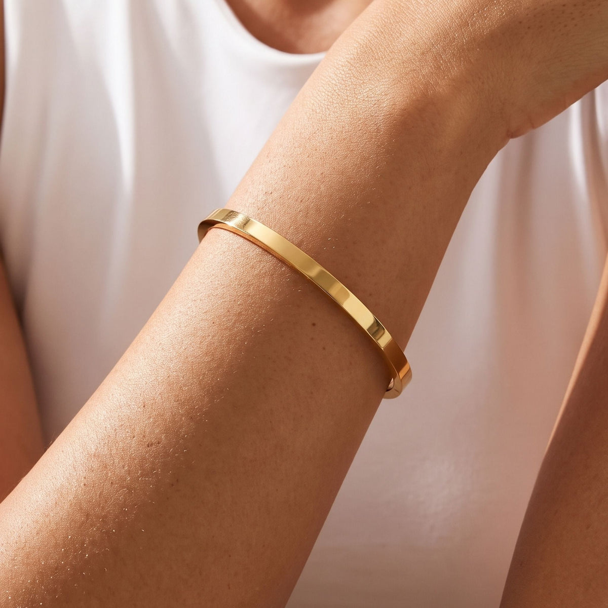 Flat Gold Bangle worn on the wrist, photographed in natural daylight.