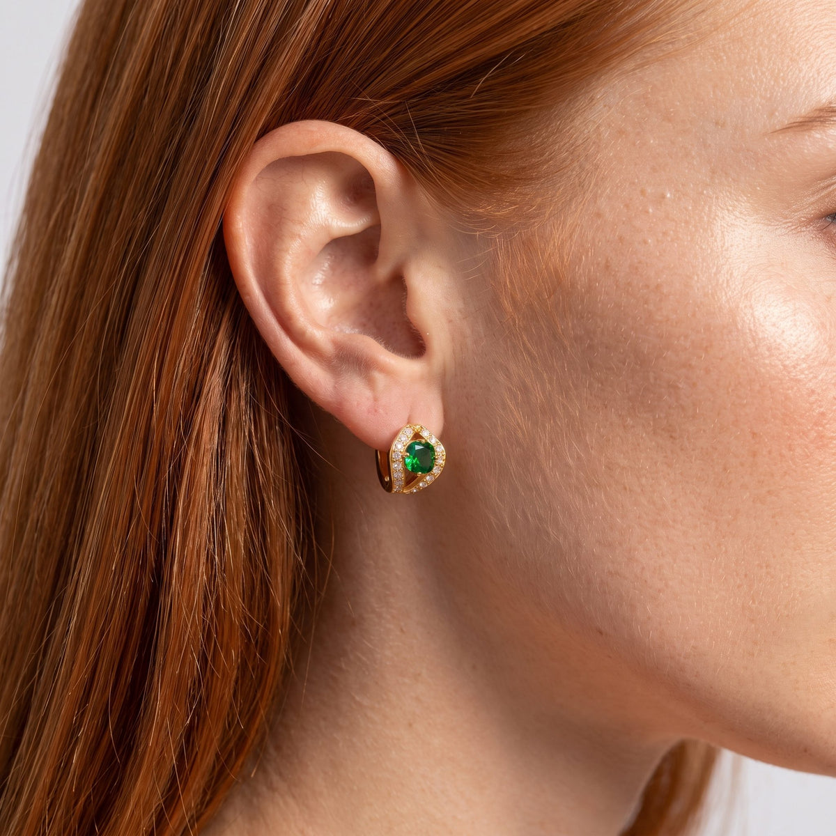 Woman wearing the Green Split Halo Huggies on her ear with straight red hair tucked behind