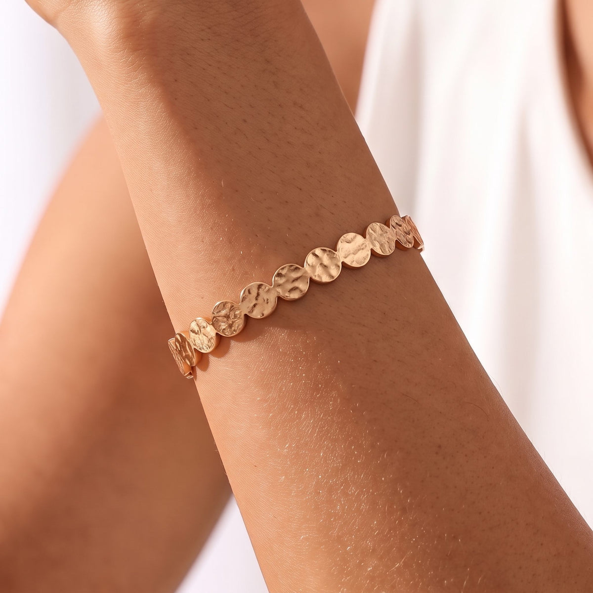 Close-up of the Hammered Disc Cuff on the wrist, showing its textured rose gold disc pattern