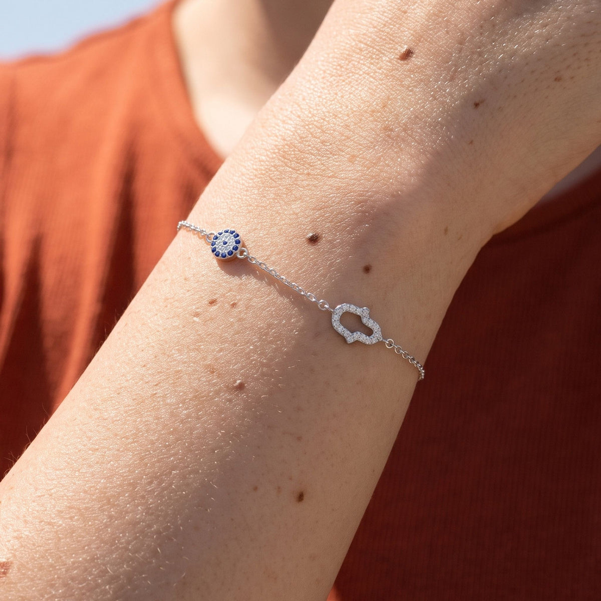 Hamsa & Eye Bracelet worn on the wrist, photographed in natural daylight.