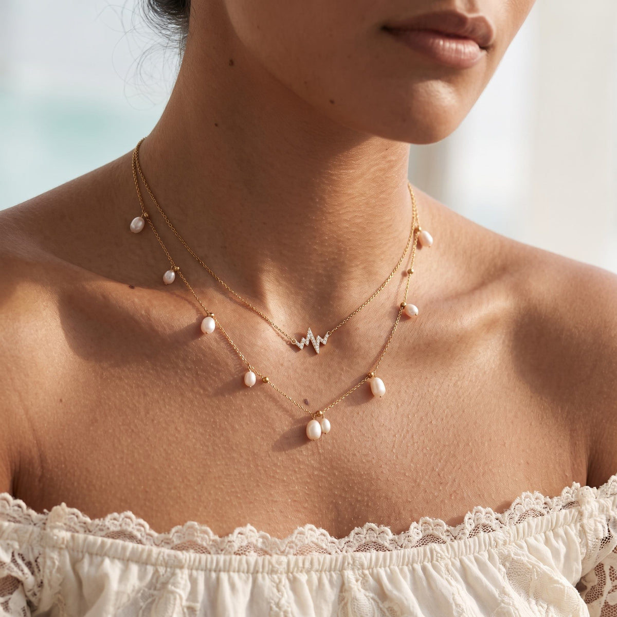 Wider view of a woman wearing the Heartbeat Pearl Necklace