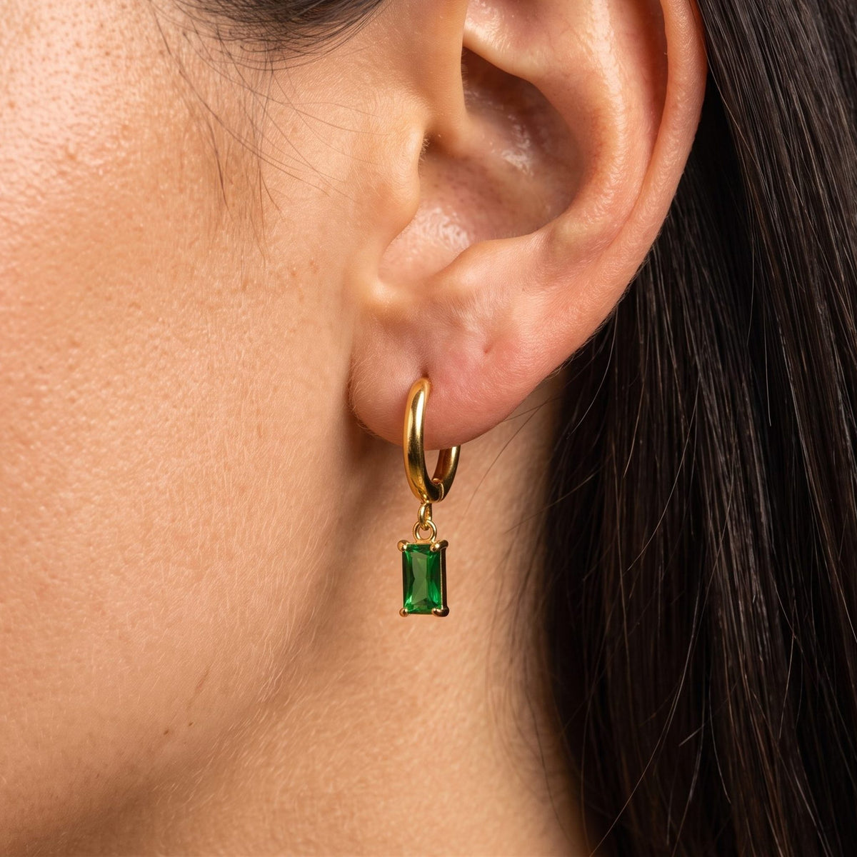 Woman wearing the Jasmine Green Earrings through the lobe with a green rectangular charm
