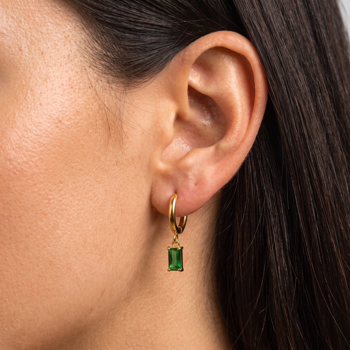 Woman wearing the Jasmine Green Earrings through the lobe with a green rectangular charm