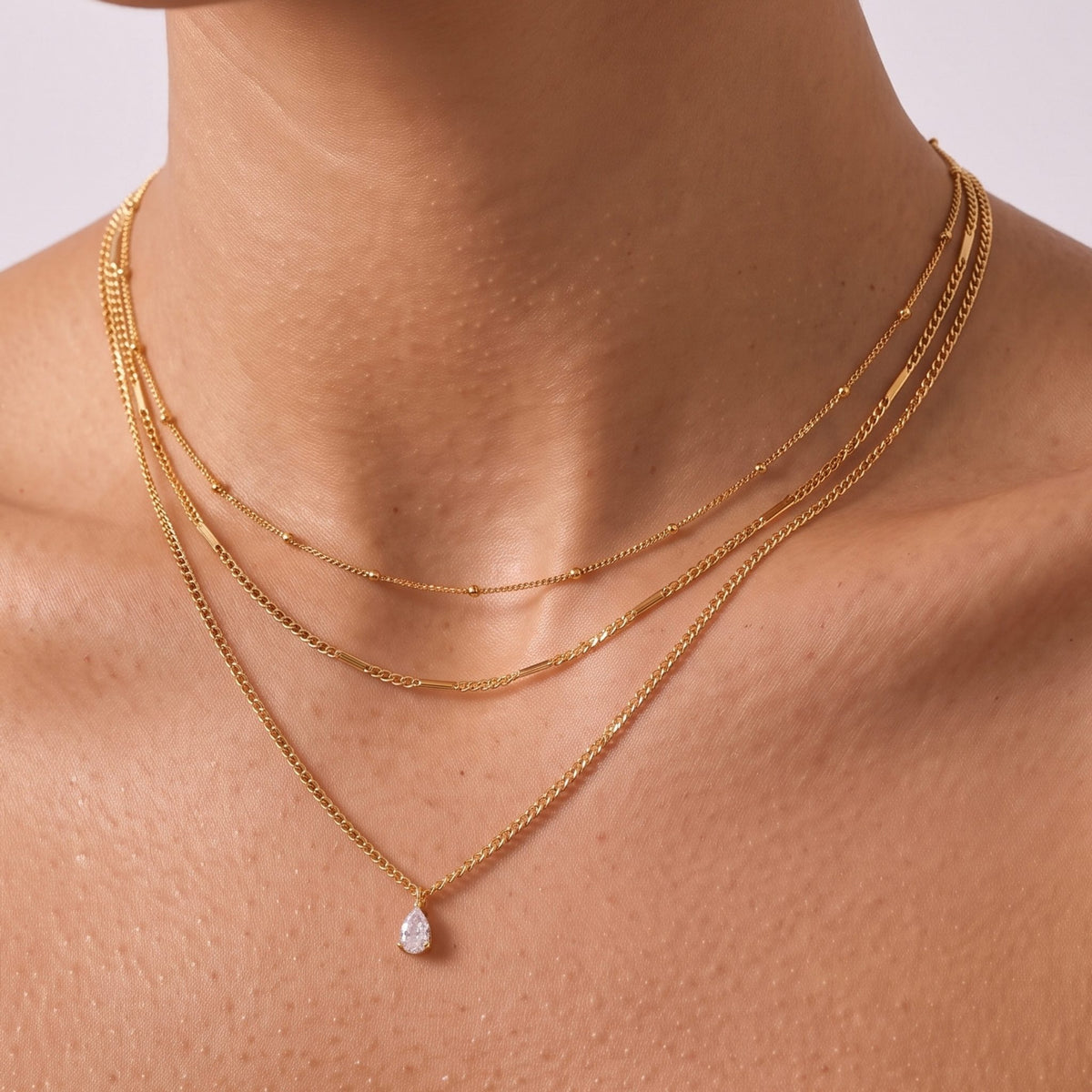 Close-up of the Layered Teardrop Necklace at the collarbone, featuring a delicate crystal pendant
