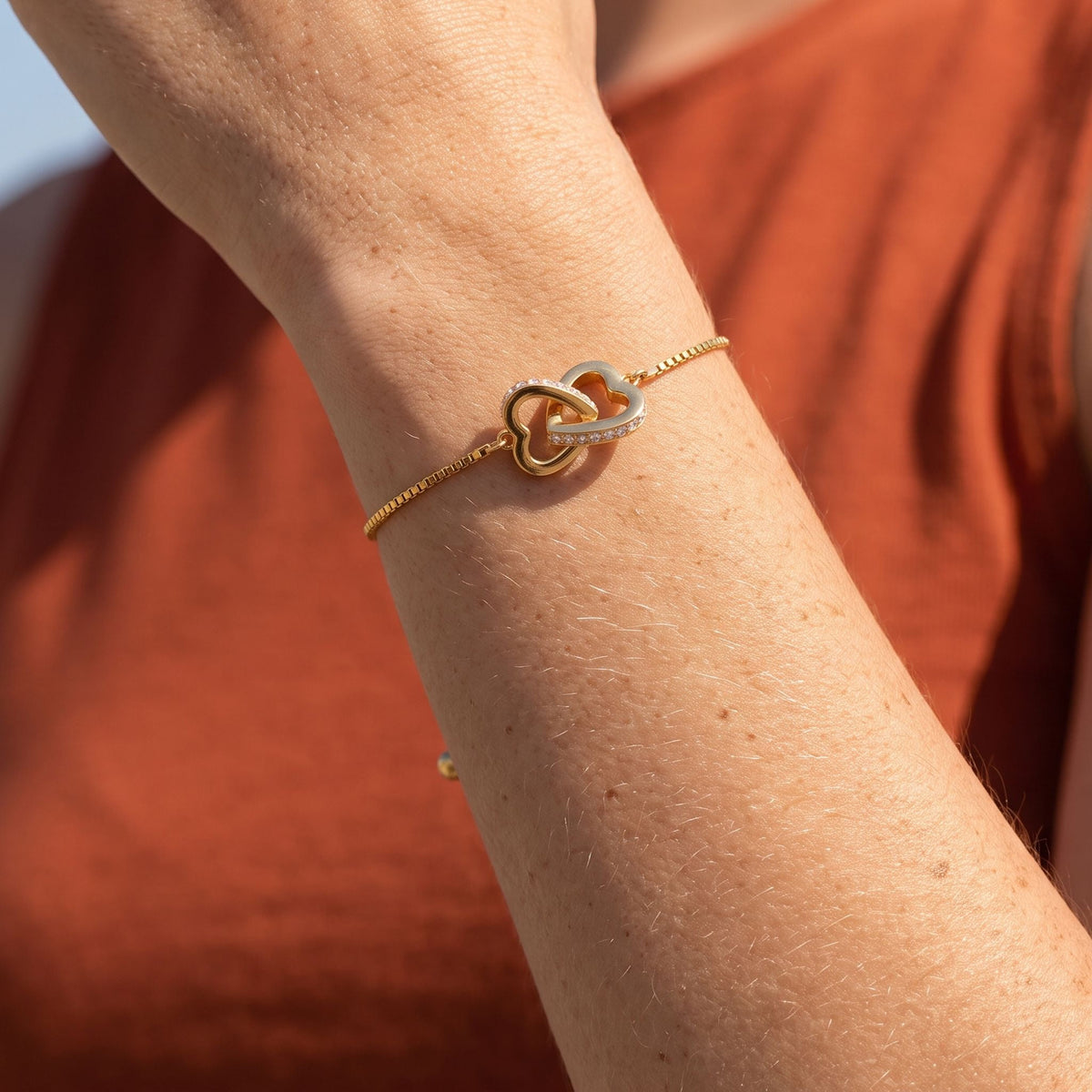 Linked Heart Bracelet worn on the wrist, photographed in natural daylight.