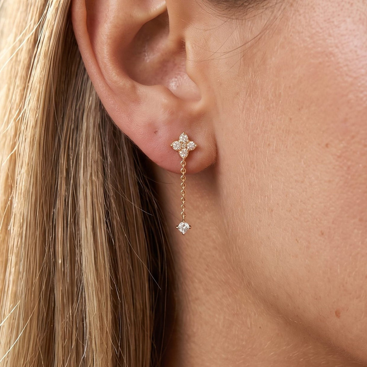 Woman wearing the Mia Crystal Drop Earrings with a delicate gold chain hanging below the lobe