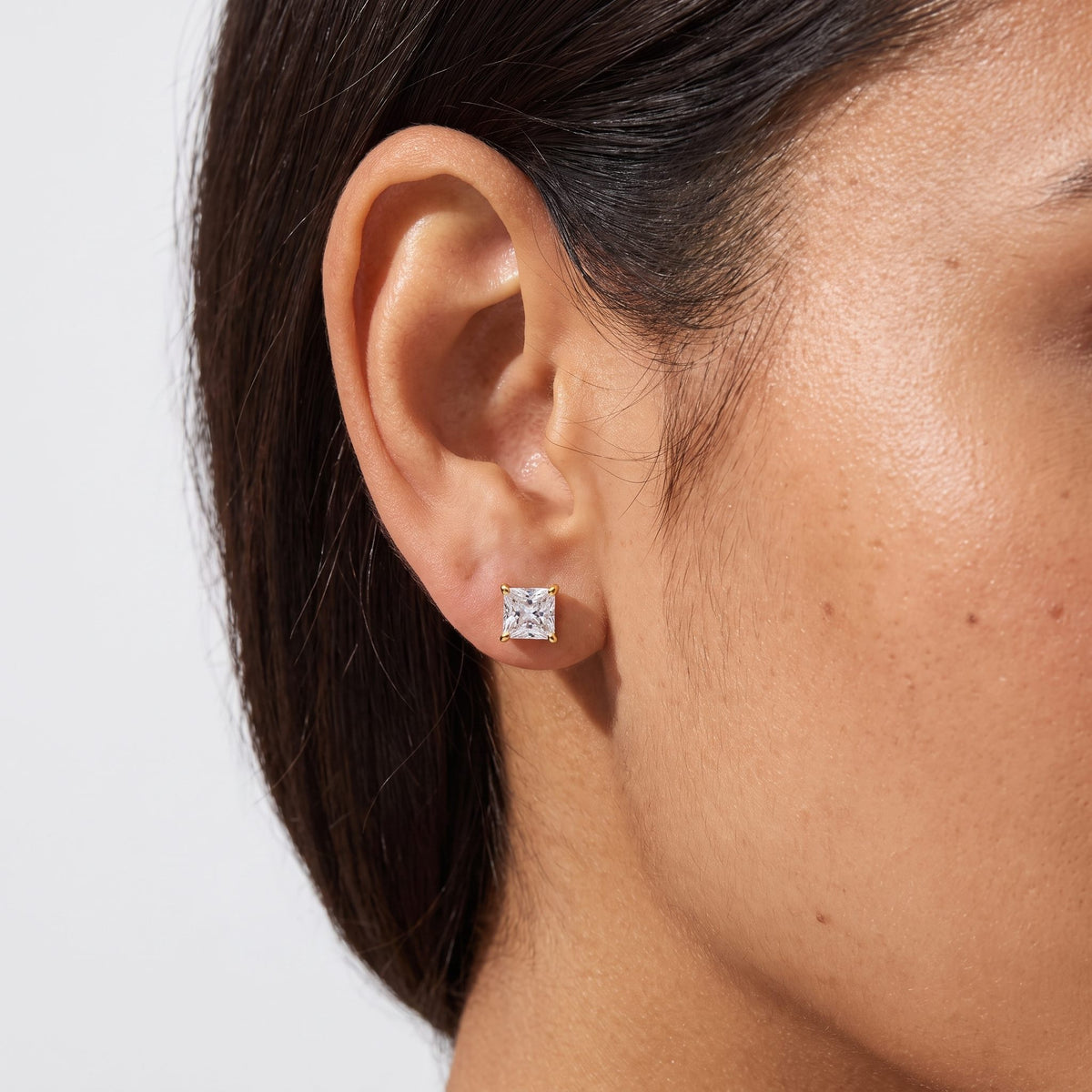 Woman wearing the Mia Square Stud Earrings on the lobe with a gold setting