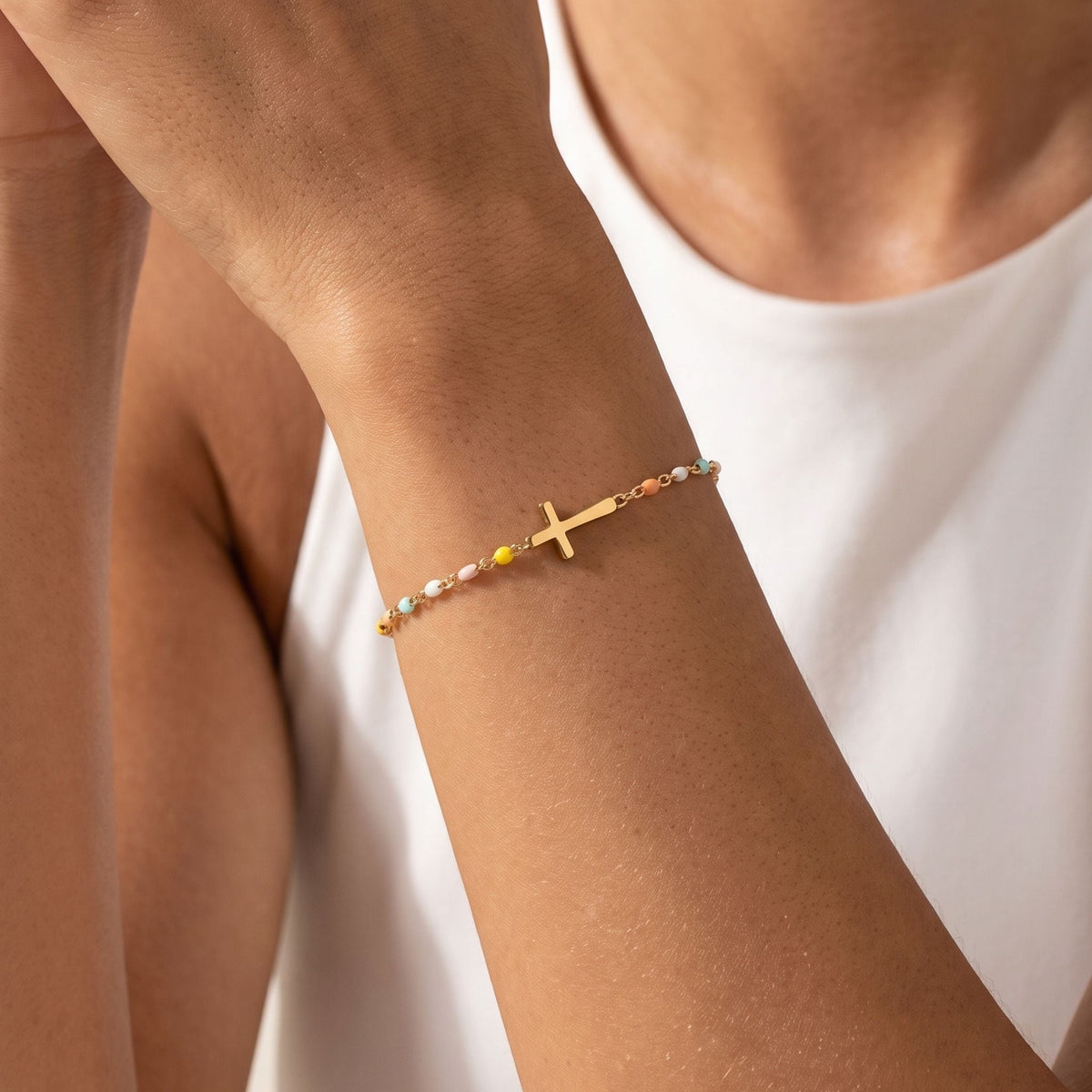 Pastel Cross Bracelet worn on the wrist, photographed in natural daylight.
