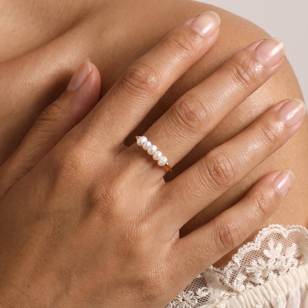 Close-up of the Pearl Row Ring worn on the finger
