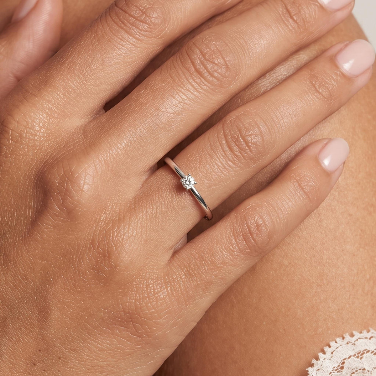 Close-up of the Petite Solitaire Ring worn on the finger