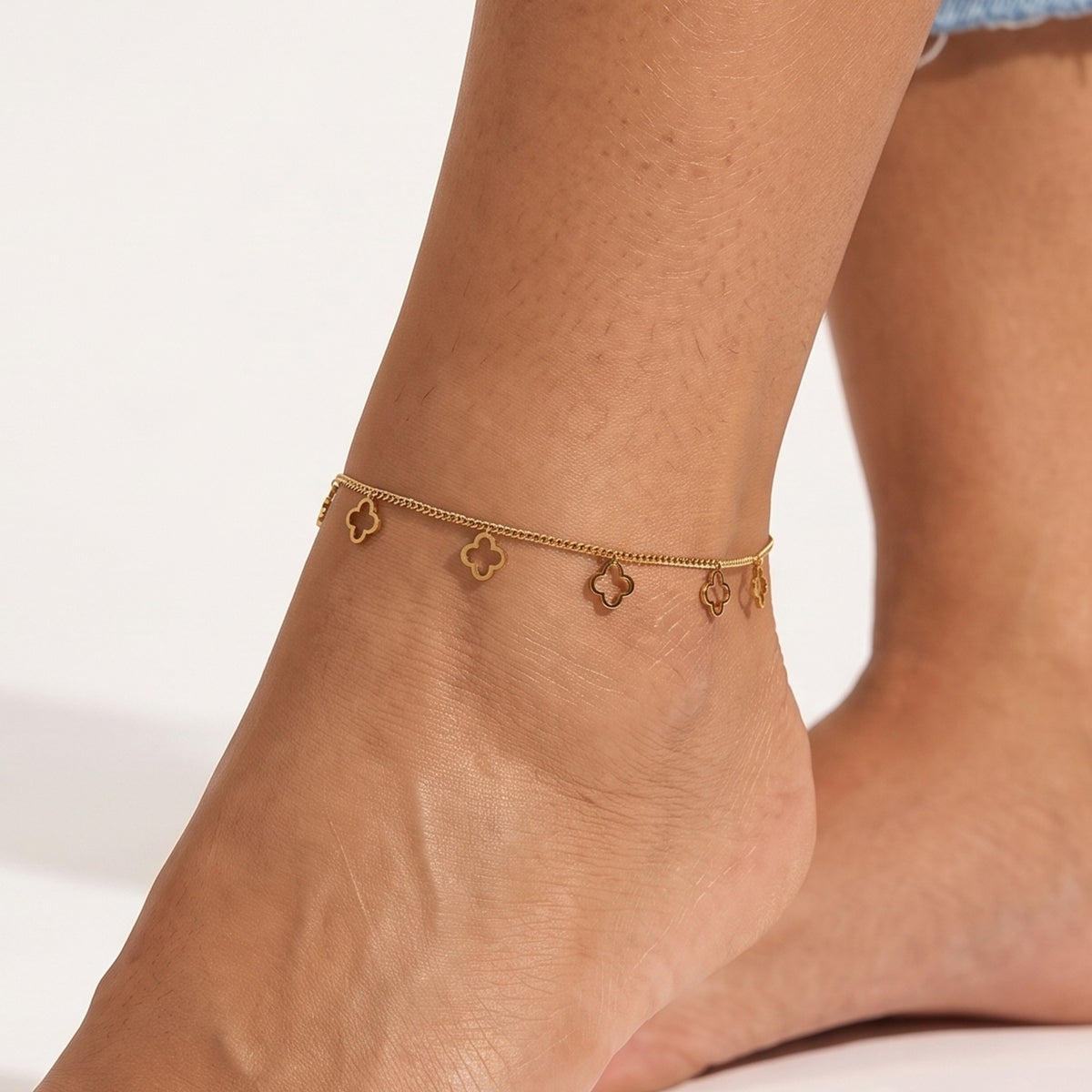 Close-up of the Polished Clover Anklet worn on the ankle