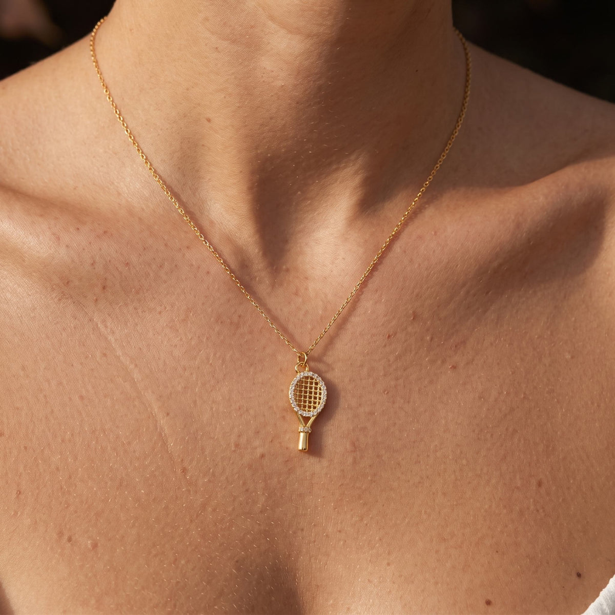 Close-up of the Racket Pendant worn on the neckline