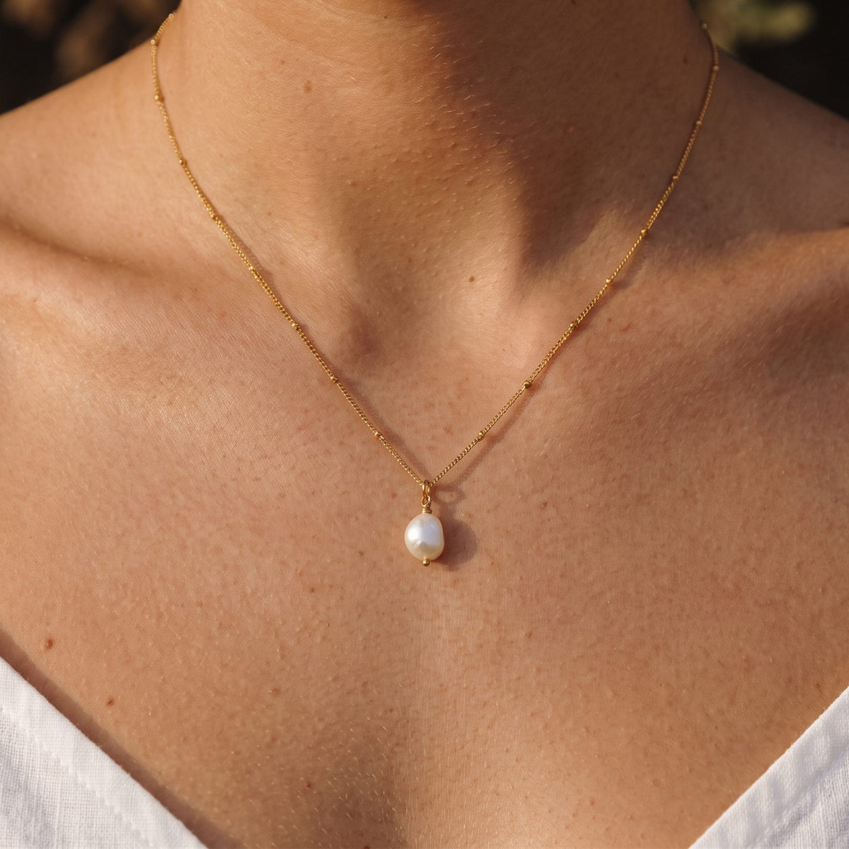 Close-up of the Round Pearl Pendant worn on the neckline