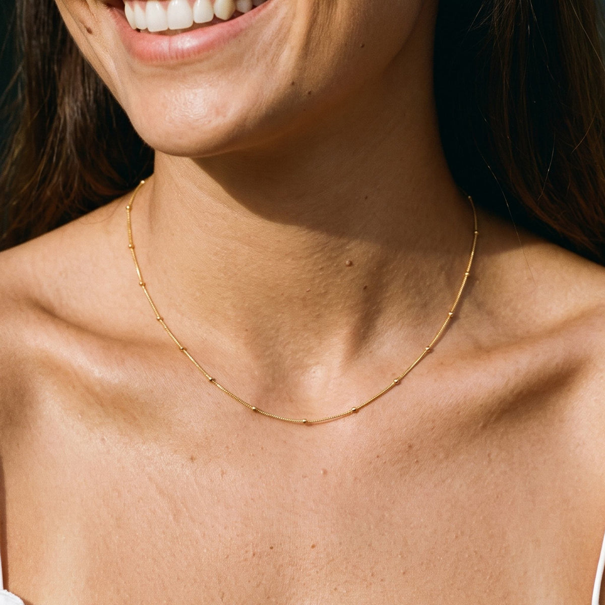 Close-up of the Satellite Chain Necklace worn on the neckline