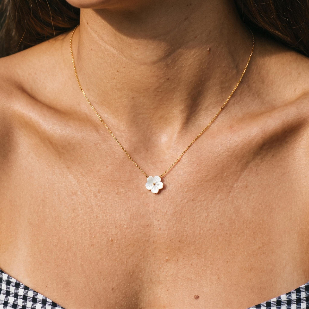 Close-up of the Shell Bloom Pendant worn on the neckline