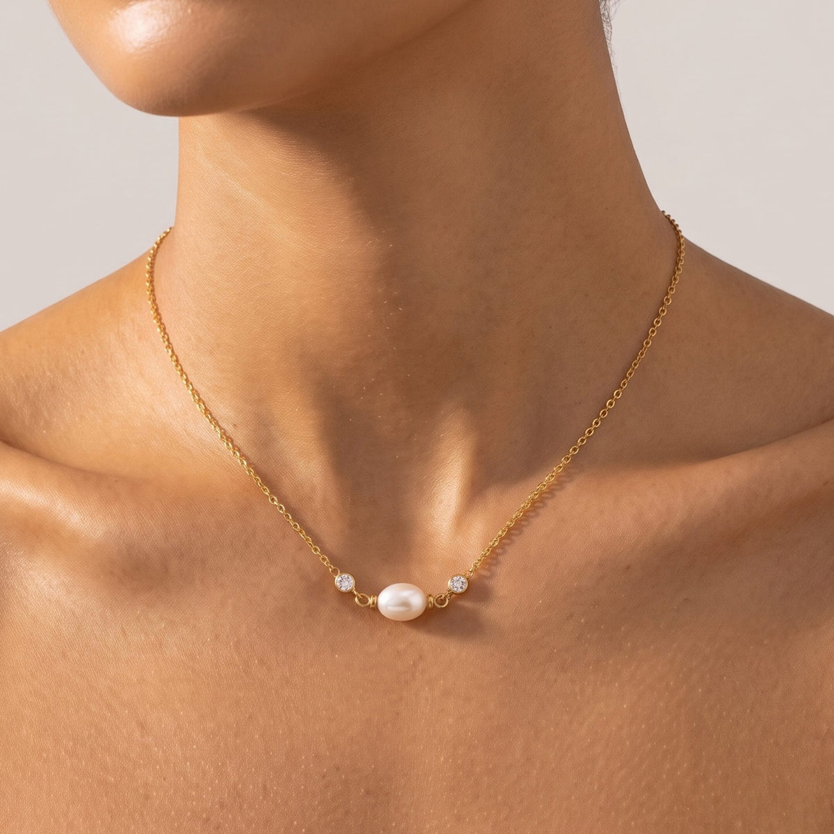 Close-up of the Sideways Pearl Necklace at the collarbone flanked by bezel-set crystals