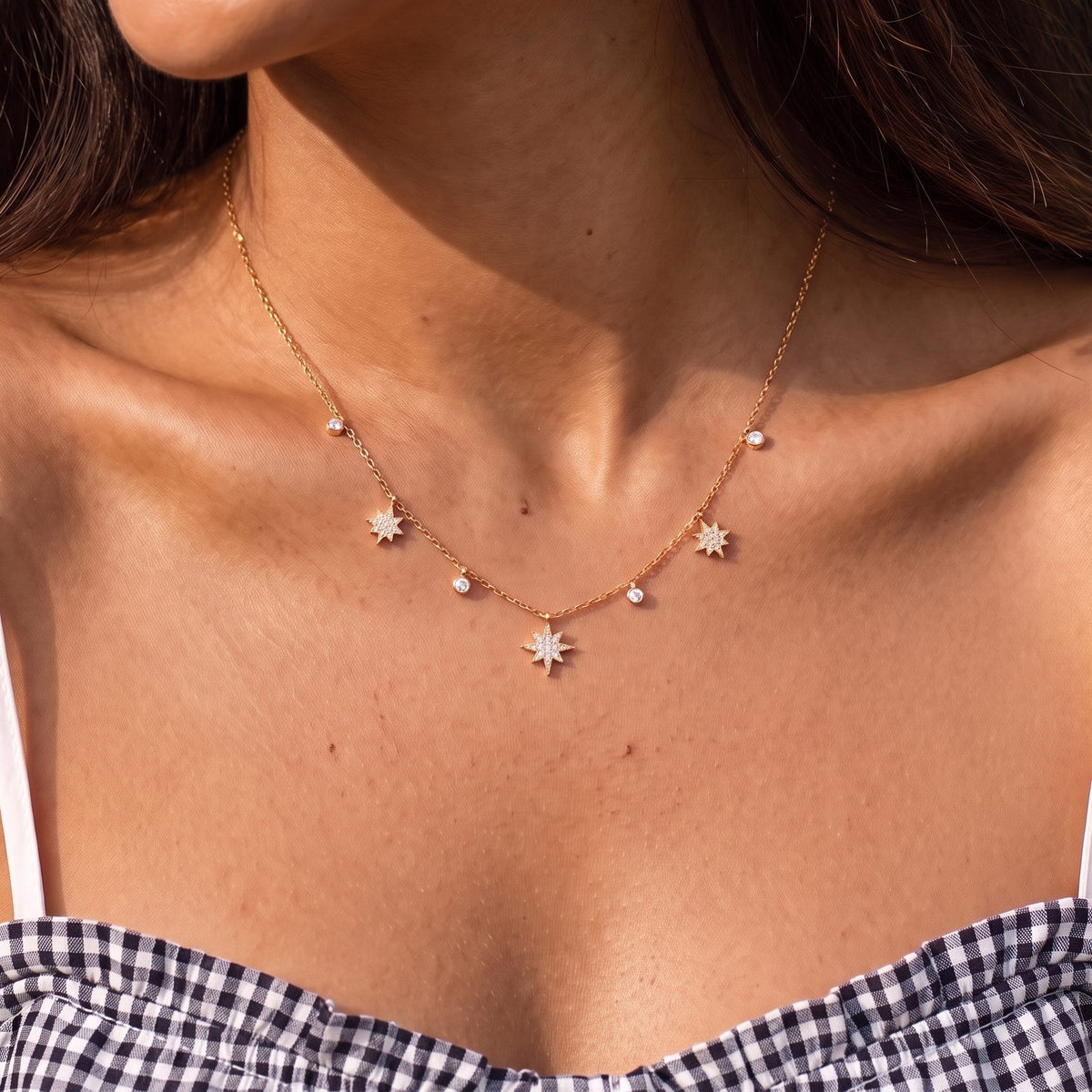 Close-up of the Star Charm Necklace worn on the neckline, in rose gold