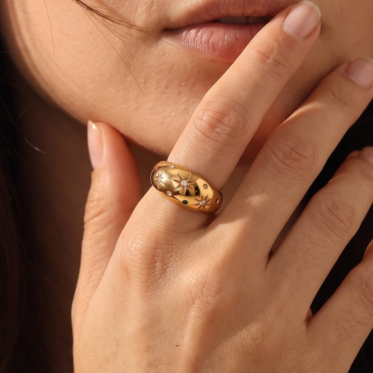 Close-up of the Star Dome Ring on a hand, highlighting its starburst-engraved crystals