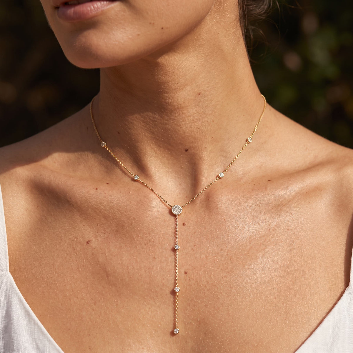 Woman wearing the Station Lariat Necklace on the neckline