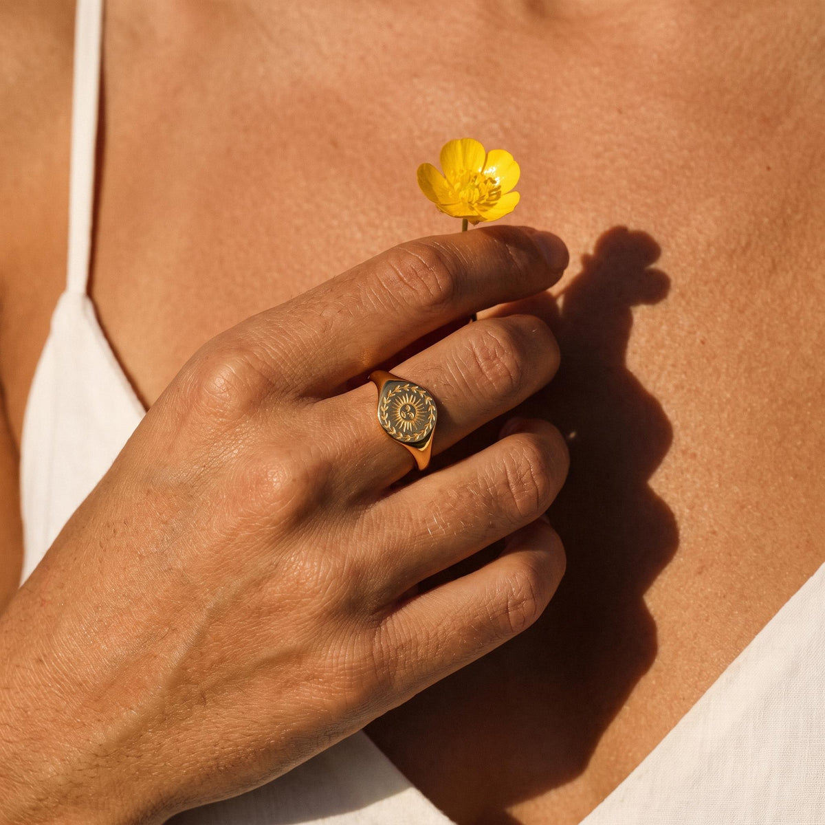Wider view of a hand wearing the Sunflower Signet Ring