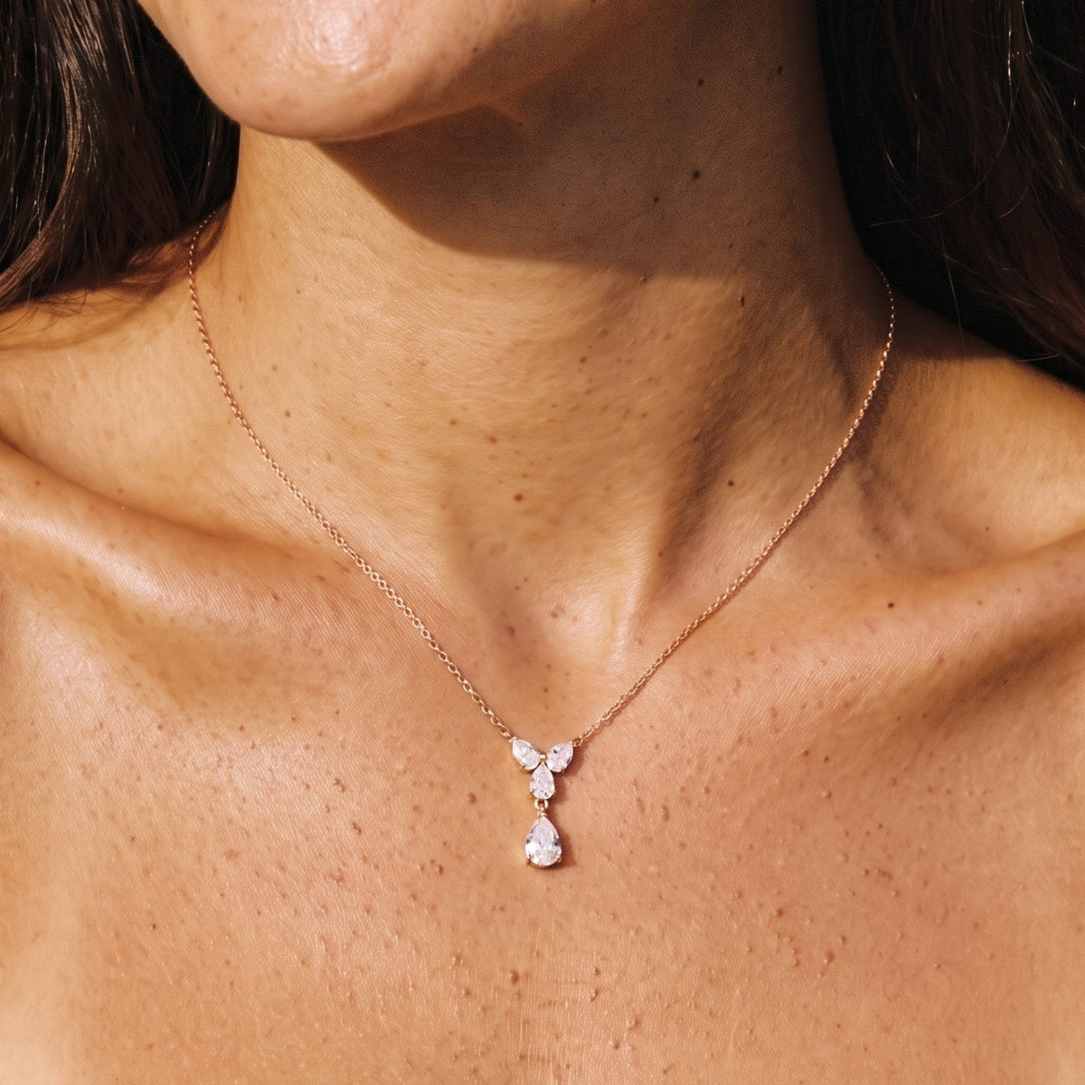 Close-up of the Teardrop Cluster Pendant at the collarbone, featuring sparkling crystal stones, in rose gold