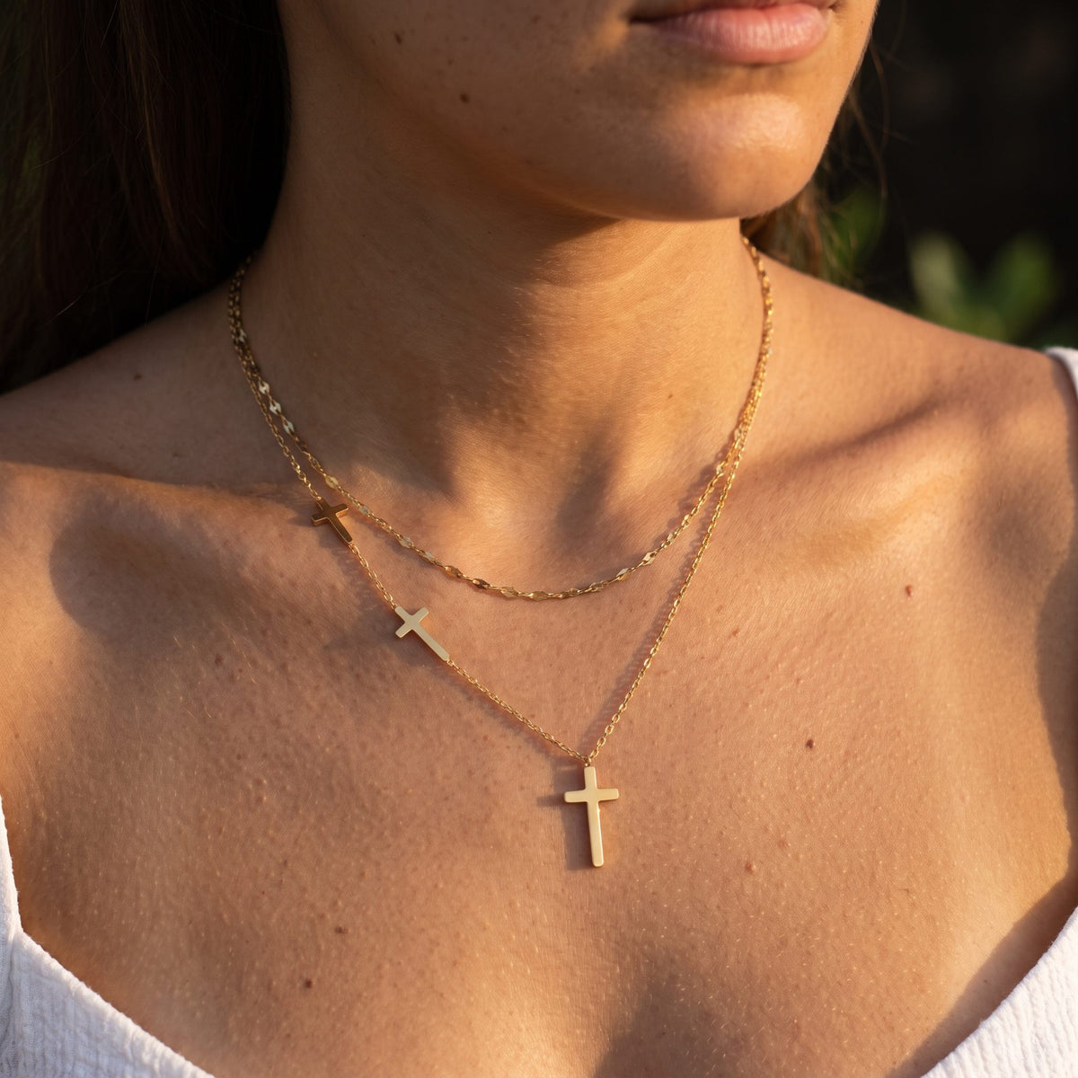 Woman wearing the Triple Cross Necklace on the neckline