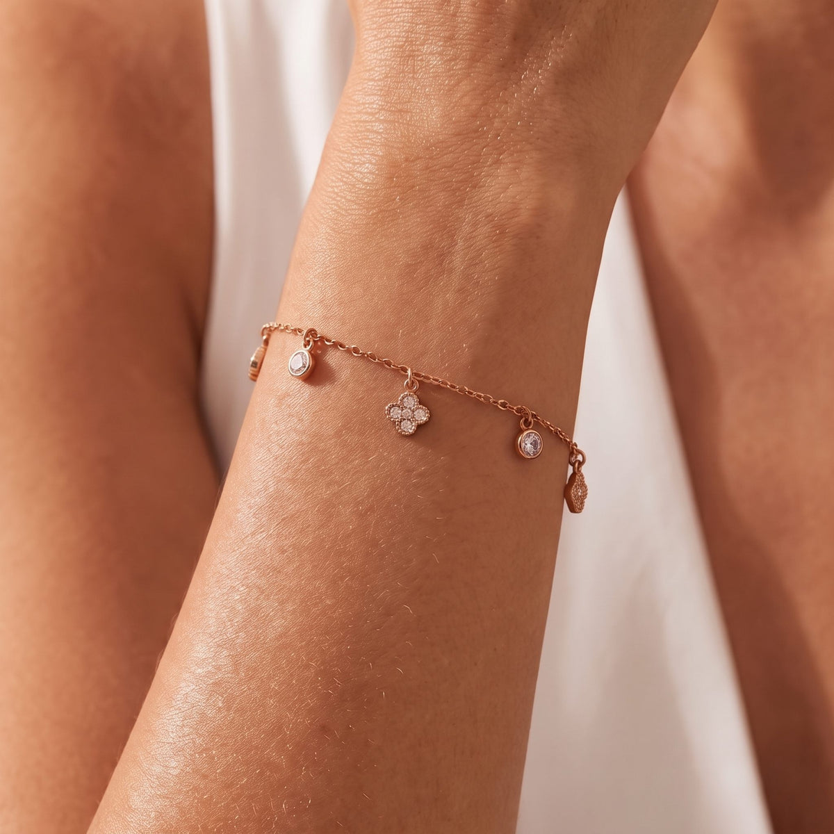 Whisper Clover Bracelet in rose gold worn on the wrist, photographed in natural daylight