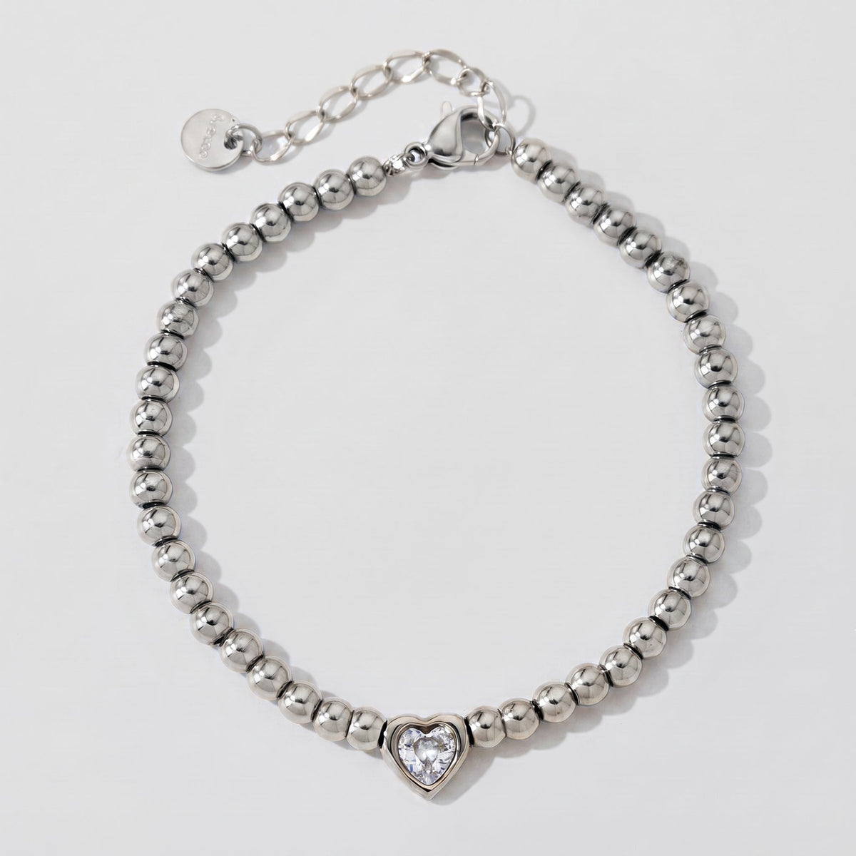 Aurélie heart beaded silver bracelet laid flat in a circle, showing the clasp, extender chain and heart charm