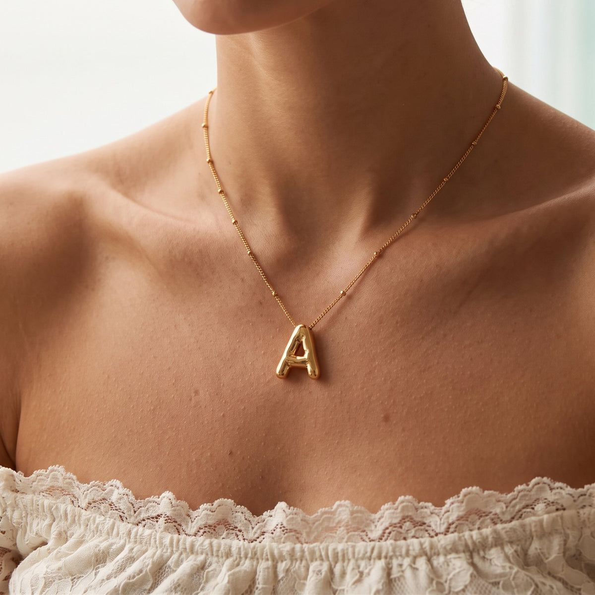 Close-up of the Balloon Initial Necklace worn on the neckline