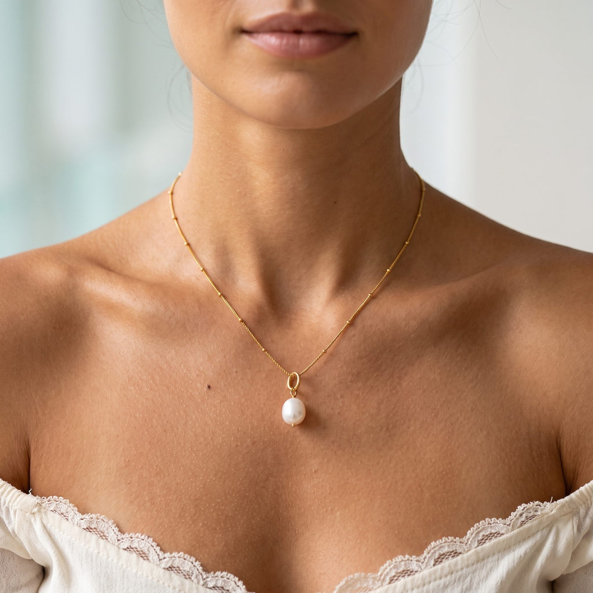 Wider view of a woman wearing the Baroque Pearl Pendant