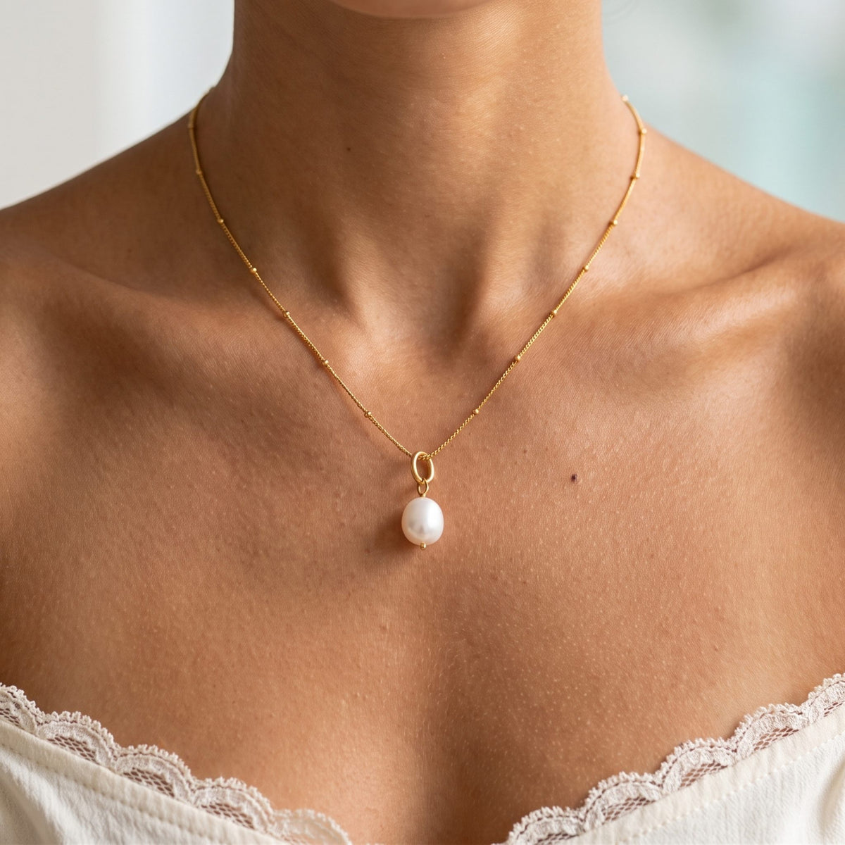 Close-up of the Baroque Pearl Pendant worn on the neckline