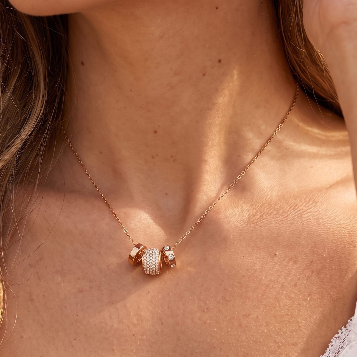 Close-up of the Barrel Charm Necklace at the collarbone, highlighting its sparkling pavé crystal embellishments, in rose gold