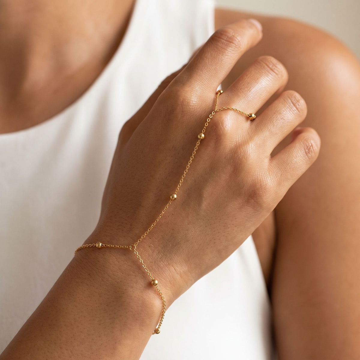 Bead Hand Chain worn across the back of the hand, with the ring on the finger and the chain at the wrist.