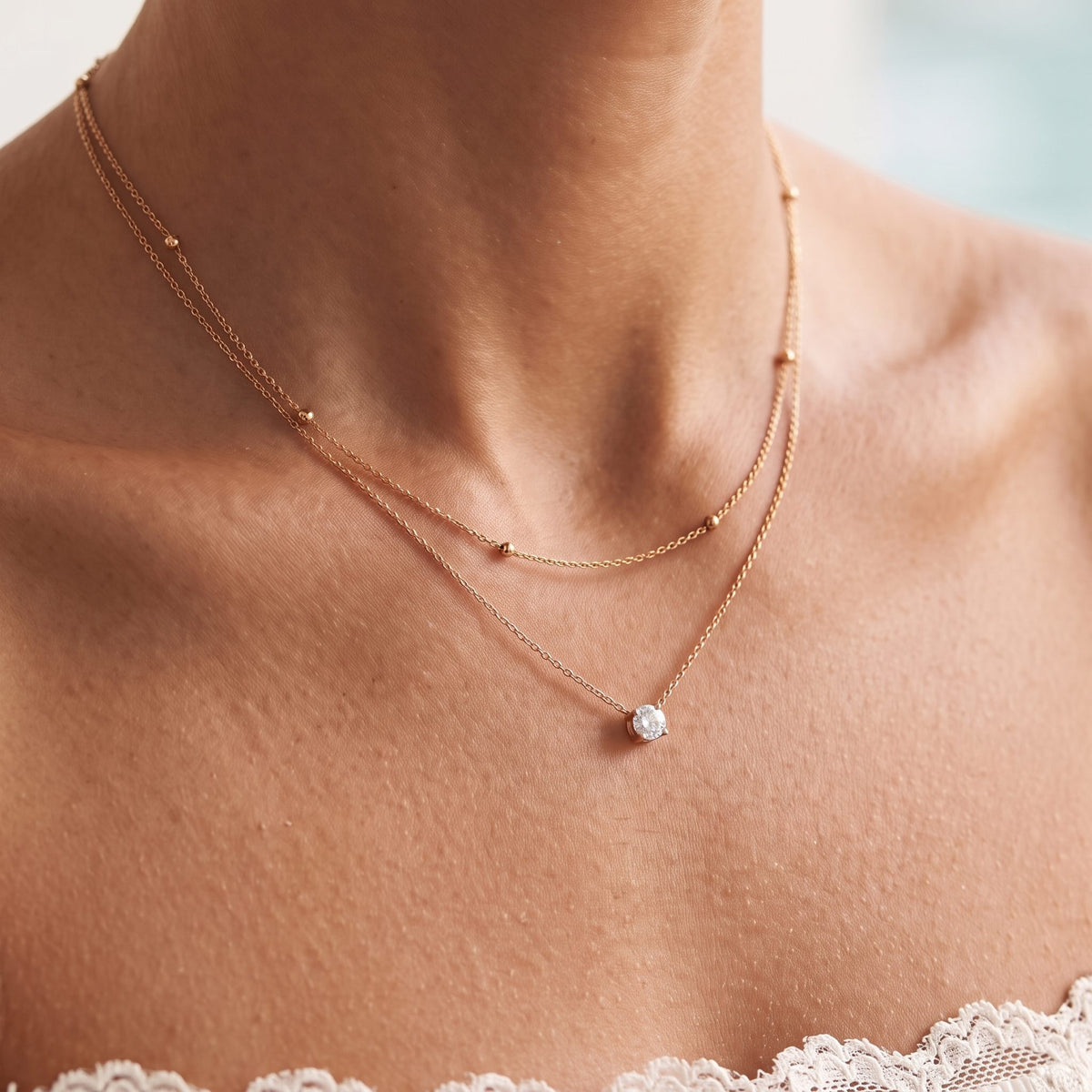Close-up of the Beaded Layer Necklace worn on the neckline, in rose gold