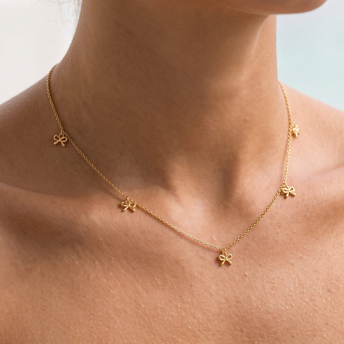 Close-up of the Bow Drop Necklace worn on the neckline