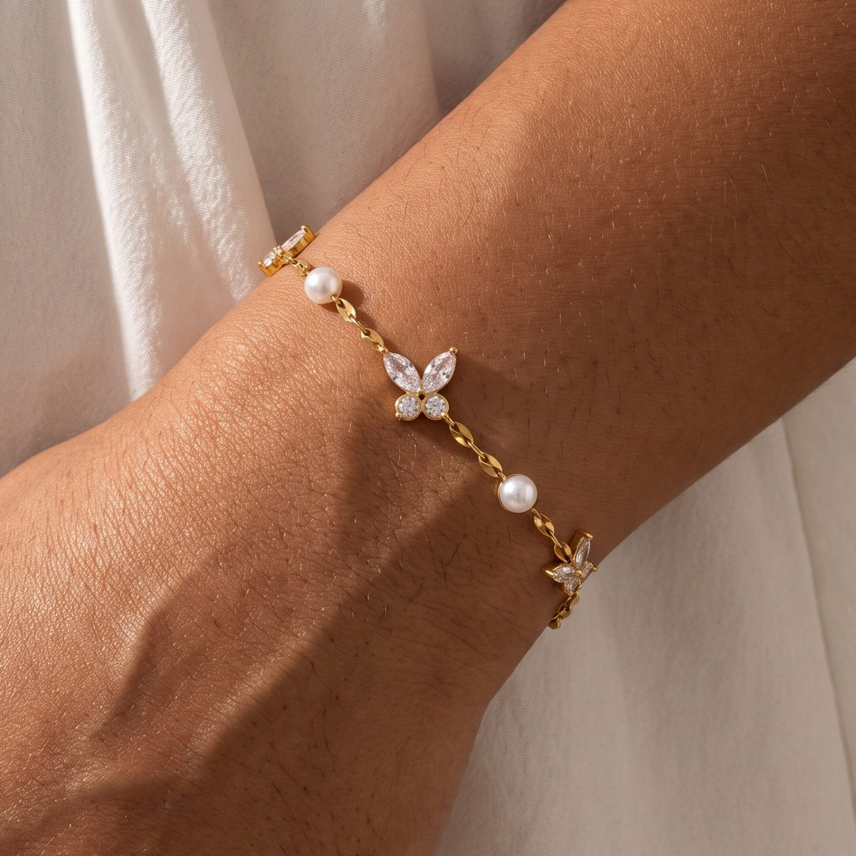 Close-up of the Butterfly & Pearl Bracelet on the wrist showing the delicate crystal butterfly