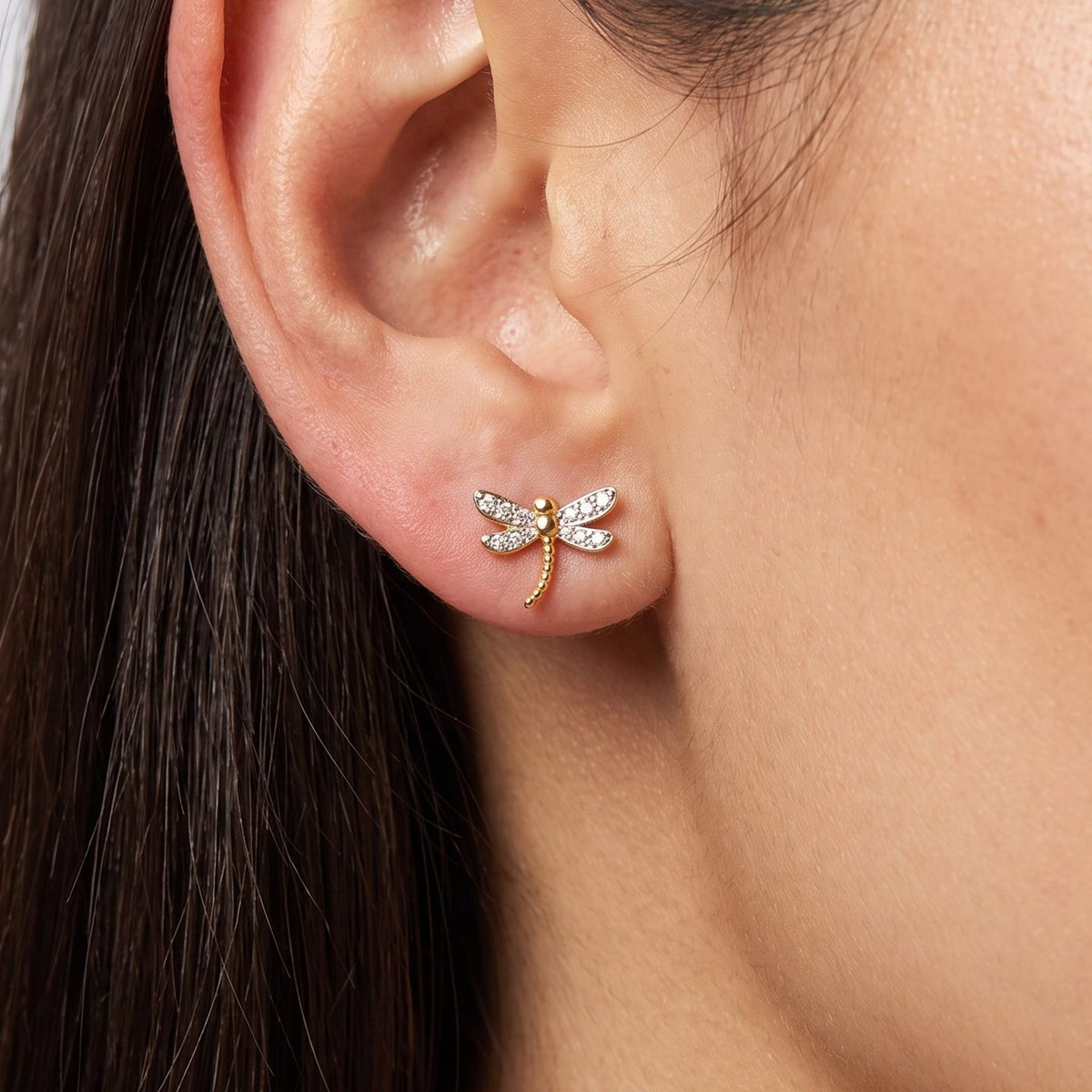 Woman wearing the Camila Dragonfly Stud Earrings flat to the lobe with sparkling wings